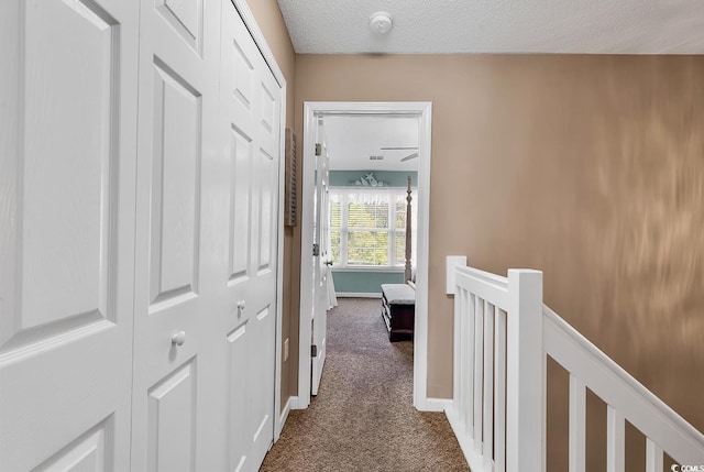 1046 Palisade Cir Unit 1046, Myrtle Beach, SC 29577 - hallway featuring dark carpet, an upstairs landing, baseboards, and a textured ceiling