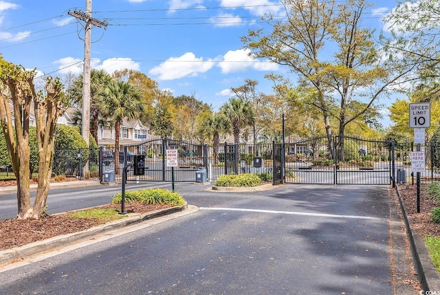 1046 Palisade Cir Unit 1046, Myrtle Beach, SC 29577 - view of asphalt road with a gate, traffic signs, curbs, and a gated entry