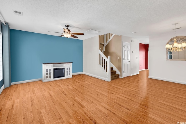 1046 Palisade Cir Unit 1046, Myrtle Beach, SC 29577 - unfurnished living room with stairs, light wood-type flooring, a textured ceiling, a chandelier, and ceiling fan