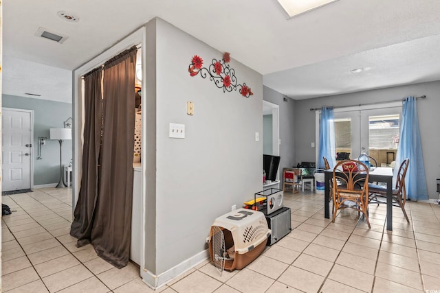 interior space with baseboards, light tile patterned flooring, and visible vents