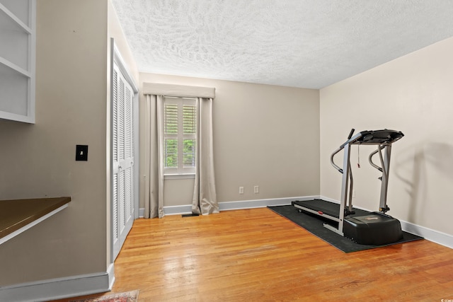 5033 Brantwood Dr, Mullins, SC 29574 - workout area featuring light wood-style floors, a textured ceiling, and baseboards