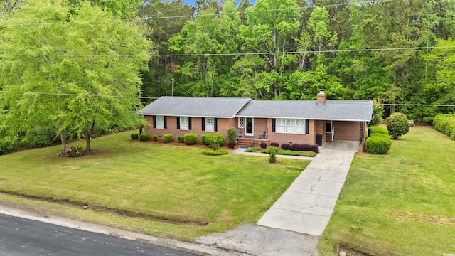 5033 Brantwood Dr, Mullins, SC 29574 - ranch-style house with a chimney, a front lawn, driveway, a view of trees, and brick siding