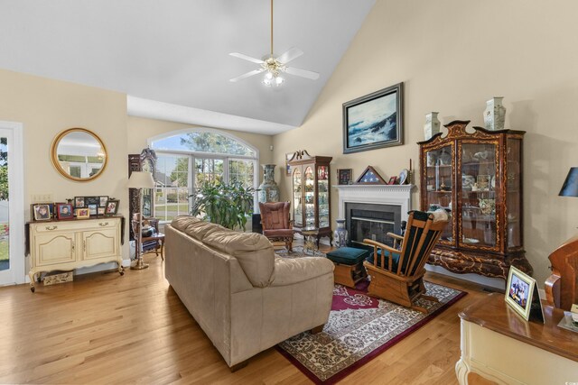 414 Staghorn Ln, Longs, SC 29568 - living room featuring high vaulted ceiling, a ceiling fan, a glass covered fireplace, and light wood finished floors