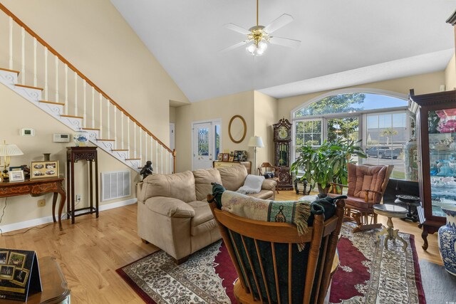 414 Staghorn Ln, Longs, SC 29568 - living room featuring high vaulted ceiling, stairway, wood finished floors, ceiling fan, and visible vents