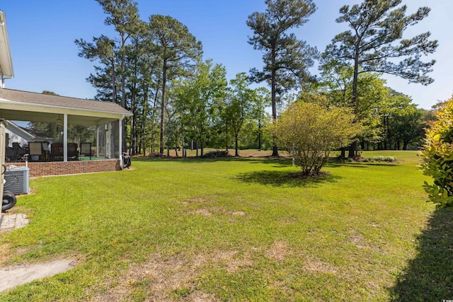 view of yard with a sunroom and central AC
