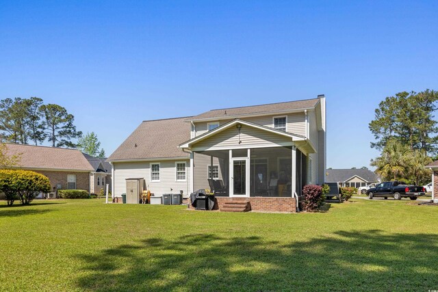 414 Staghorn Ln, Longs, SC 29568 - back of property with a sunroom, a chimney, central AC unit, and a lawn