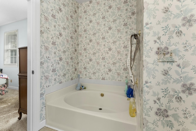 bathroom featuring a bath, wallpapered walls, and baseboards
