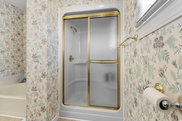 full bath featuring a tub to relax in, wallpapered walls, and a stall shower