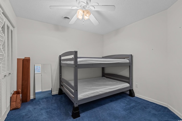 unfurnished bedroom with a textured ceiling, a ceiling fan, visible vents, and carpet floors