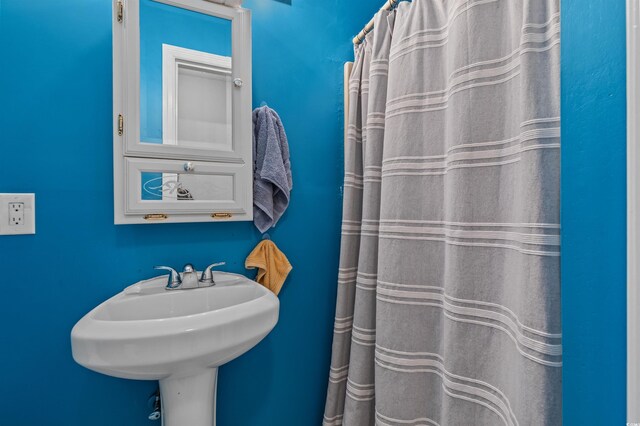 full bath featuring curtained shower and a sink