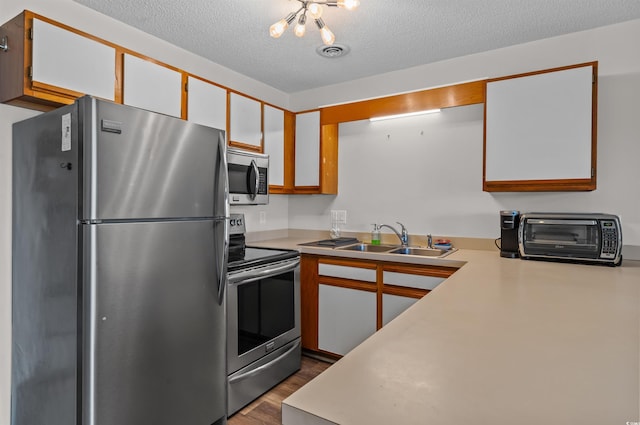 kitchen with a sink, a toaster, stainless steel appliances, visible vents, and light countertops