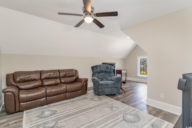 living room with a ceiling fan, baseboards, vaulted ceiling, and wood finished floors