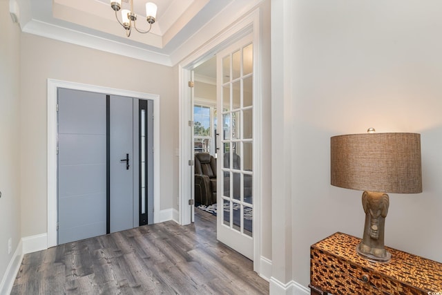 foyer featuring baseboards, a notable chandelier, and wood finished floors