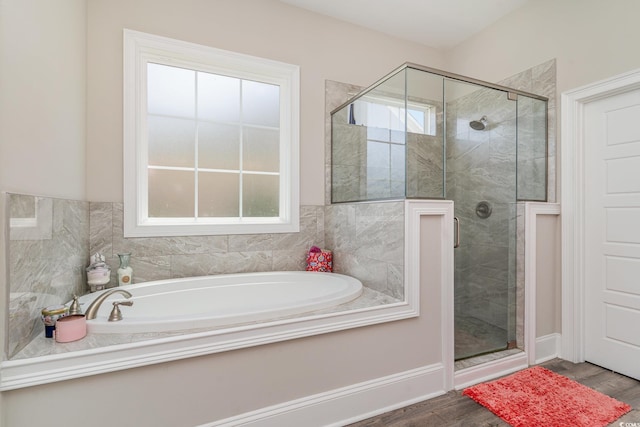 bathroom featuring a shower stall, a garden tub, and wood finished floors