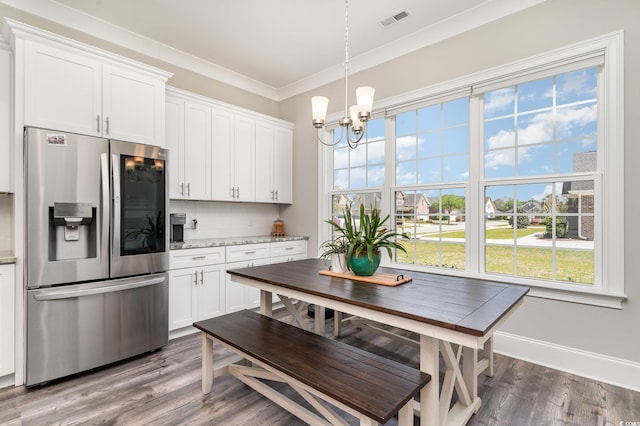 kitchen with stainless steel refrigerator with ice dispenser, visible vents, crown molding, wood finished floors, and a notable chandelier