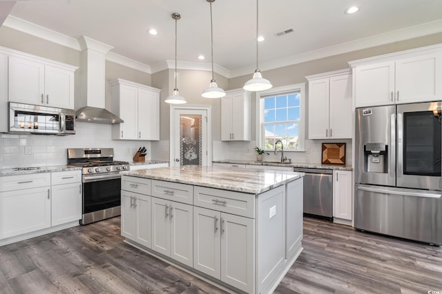 kitchen with visible vents, crown molding, a center island, a sink, and stainless steel appliances