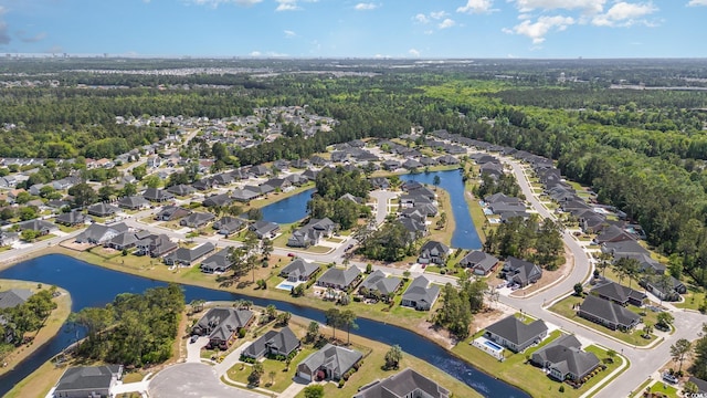 drone / aerial view with a water view, a view of trees, and a residential view