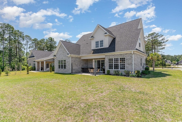 rear view of house featuring brick siding, roof with shingles, a yard, and a patio