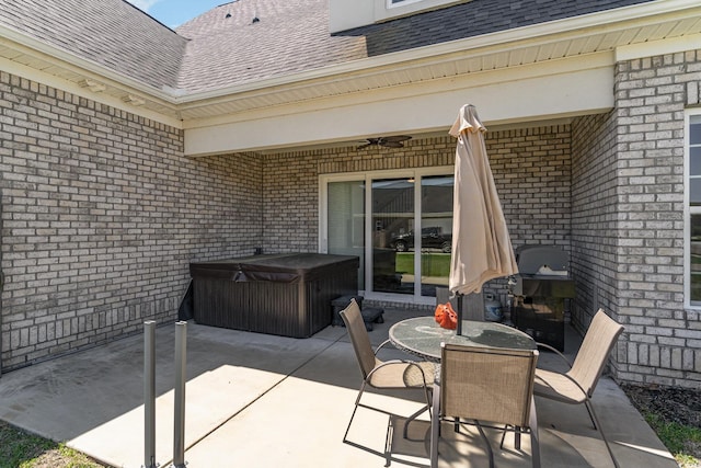 view of patio / terrace featuring outdoor dining area, ceiling fan, and a hot tub