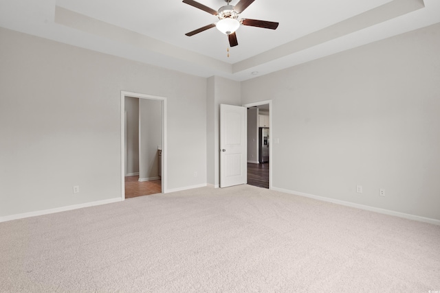 512 Charlton Blvd, Georgetown, SC 29440 - unfurnished bedroom featuring a tray ceiling, light carpet, baseboards, and ceiling fan