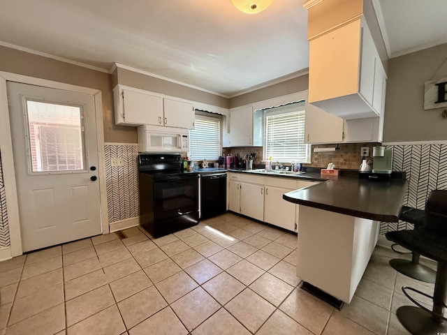 kitchen featuring black appliances, a peninsula, dark countertops, light tile patterned floors, and crown molding