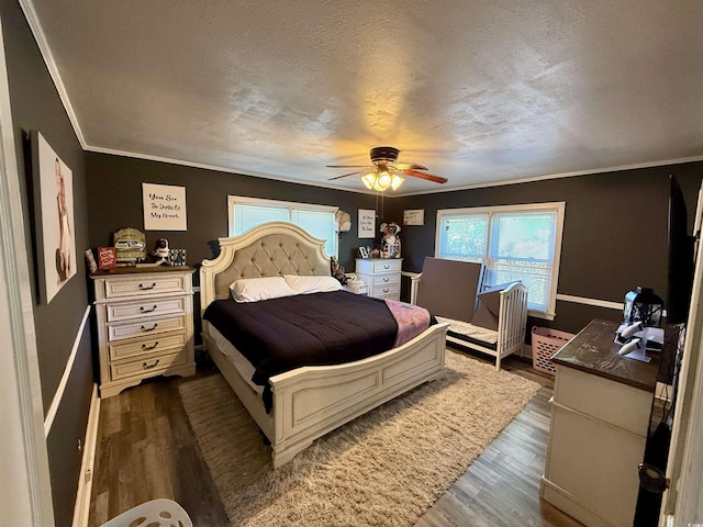 bedroom featuring dark wood finished floors, crown molding, a ceiling fan, and baseboards