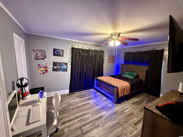 bedroom with crown molding, wood finished floors, ceiling fan, and baseboards