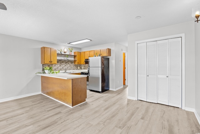 3700 Golf Colony Ln Unit 18-G, Little River, SC 29566 - kitchen with stainless steel appliances, open shelves, backsplash, a peninsula, and light wood-style flooring