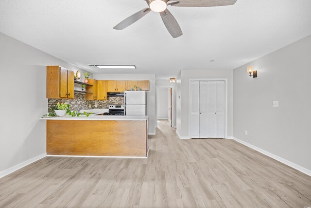 3700 Golf Colony Ln Unit 18-G, Little River, SC 29566 - kitchen featuring freestanding refrigerator, open shelves, under cabinet range hood, brown cabinetry, and light wood-style floors