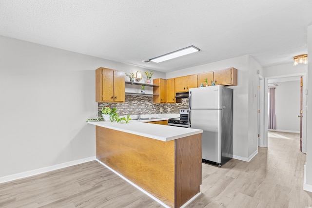 3700 Golf Colony Ln Unit 18-G, Little River, SC 29566 - kitchen with appliances with stainless steel finishes, open shelves, decorative backsplash, under cabinet range hood, and light wood-type flooring