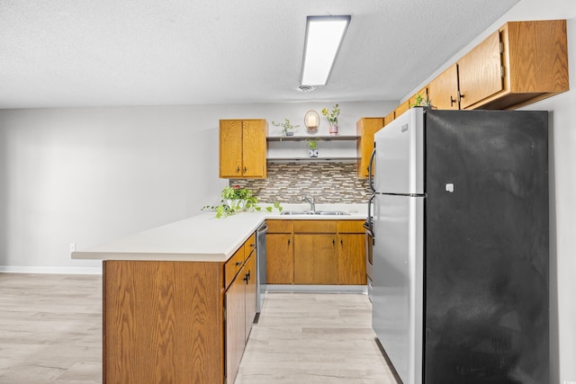 3700 Golf Colony Ln Unit 18-G, Little River, SC 29566 - kitchen featuring appliances with stainless steel finishes, a sink, light wood-type flooring, open shelves, and a textured ceiling