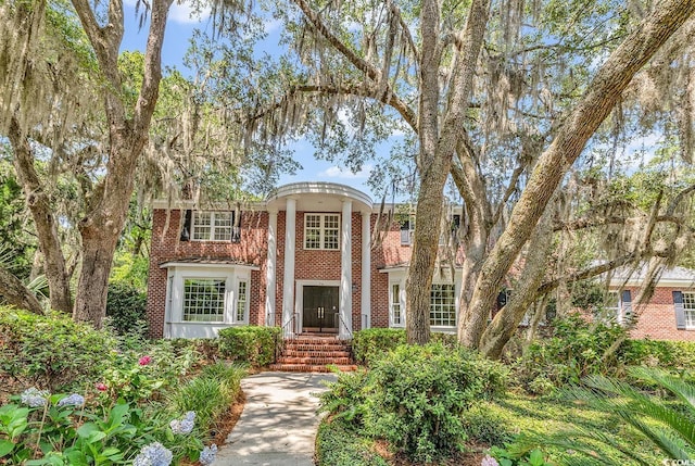 greek revival house featuring brick siding