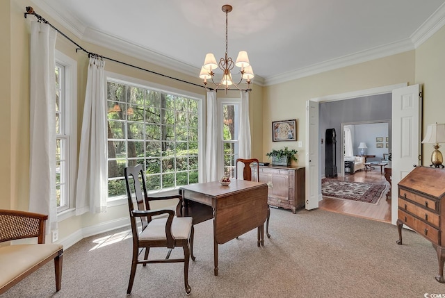 dining area featuring crown molding, a chandelier, healthy amount of natural light, and light colored carpet