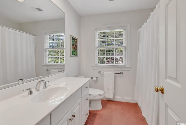 bathroom featuring plenty of natural light, toilet, baseboards, and vanity