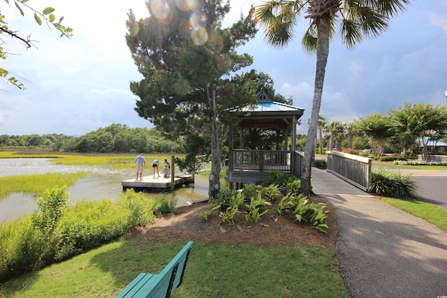 view of home's community featuring a gazebo, a water view, and a dock