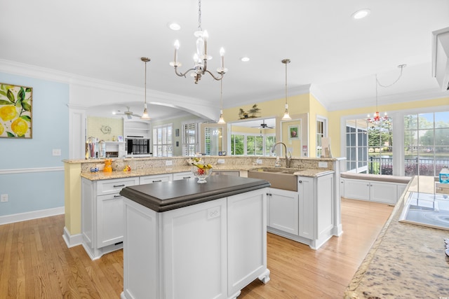 8231 Forest Lake Dr, Conway, SC 29526 - kitchen featuring light wood-style flooring, arched walkways, a sink, a spacious island, and crown molding