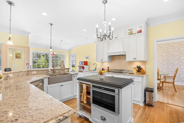 8231 Forest Lake Dr, Conway, SC 29526 - kitchen featuring light wood finished floors, a sink, custom exhaust hood, an inviting chandelier, and ornamental molding