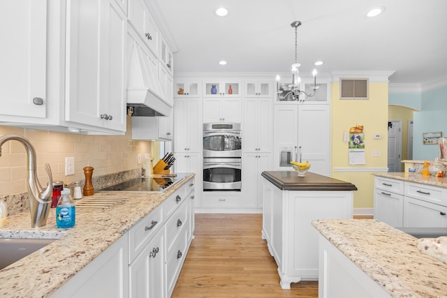 8231 Forest Lake Dr, Conway, SC 29526 - kitchen with white cabinets, visible vents, a notable chandelier, black electric stovetop, and double oven