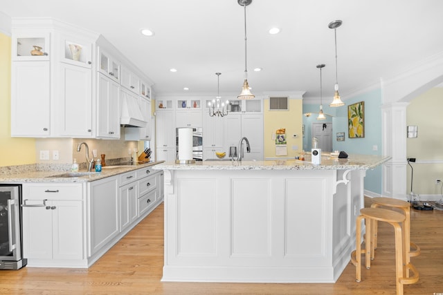 8231 Forest Lake Dr, Conway, SC 29526 - kitchen with white cabinets, beverage cooler, visible vents, a sink, and custom range hood