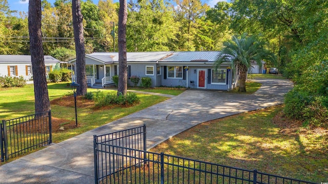 ranch-style house with concrete driveway, metal roof, and covered porch