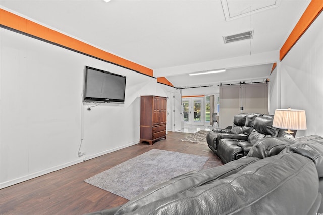 living room with attic access, wood finished floors, baseboards, and beam ceiling