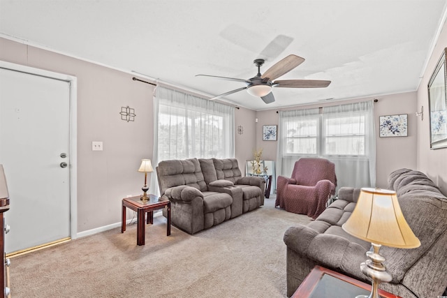 living room with a ceiling fan, crown molding, carpet, and baseboards