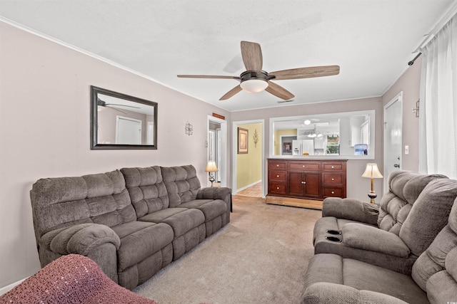 living room with ceiling fan, light carpet, and ornamental molding