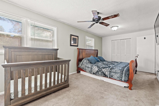 bedroom with carpet, a textured ceiling, and a ceiling fan