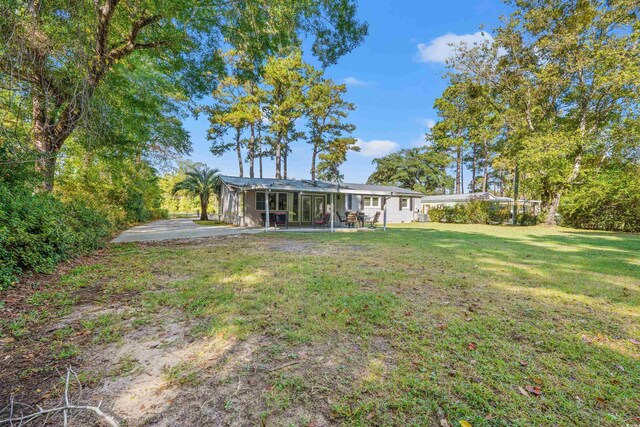 rear view of property featuring a patio area and a lawn
