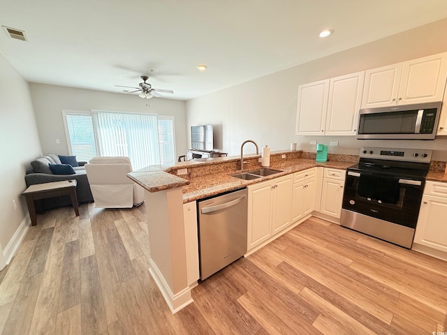 1025 World Tour Blvd Unit 205, Myrtle Beach, SC 29579 - kitchen with stainless steel appliances, visible vents, a sink, a peninsula, and light wood-style flooring