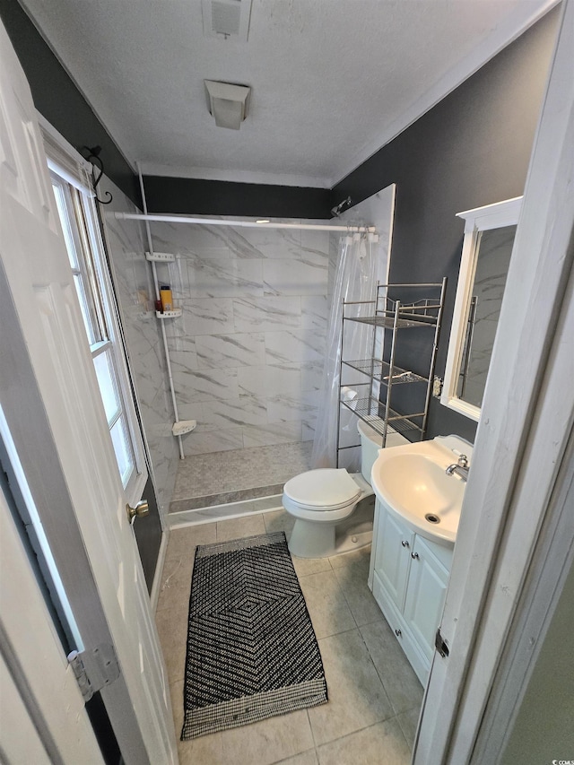 full bath with tile patterned flooring, vanity, toilet, a shower stall, and a healthy amount of sunlight