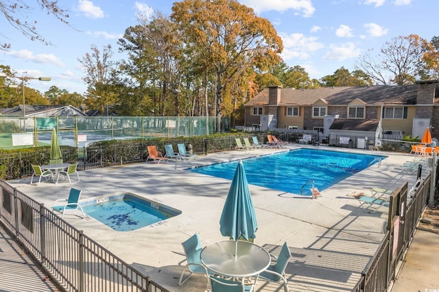 pool featuring a hot tub, fence, and a patio area
