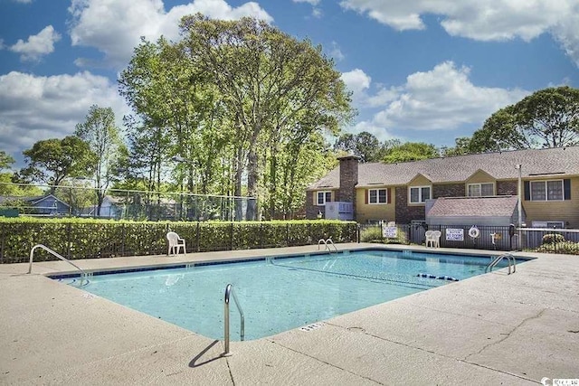 community pool featuring fence and a patio