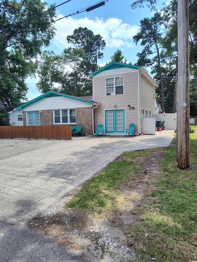 725 Juniper Dr, Surfside Beach, SC 29575 - view of front facade featuring decorative driveway, fence, and a patio area